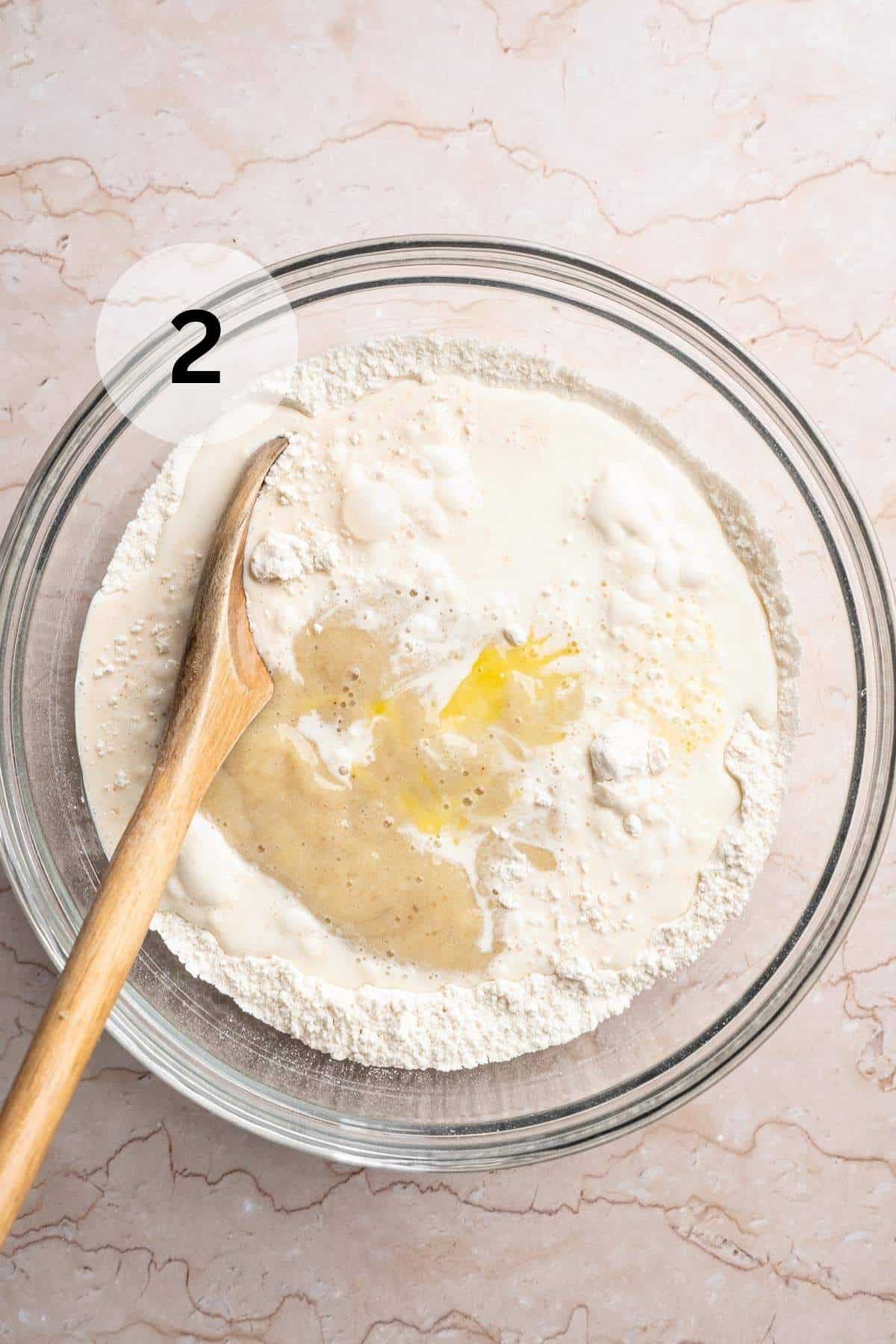 Using a wooden spoon to mix egg and milk into dry ingredients.