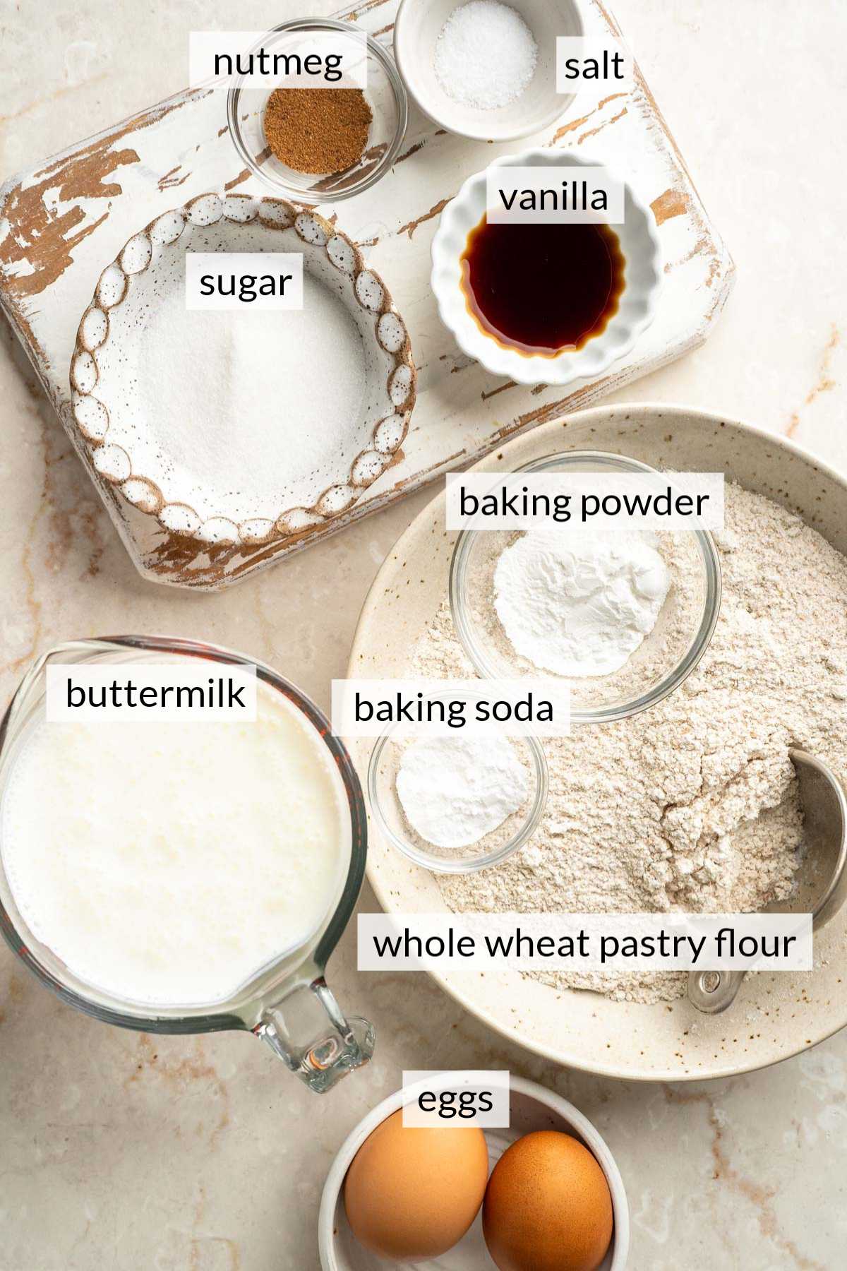 Small bowls with eggs, flour, sugar, buttermilk, vanilla and nutmeg.
