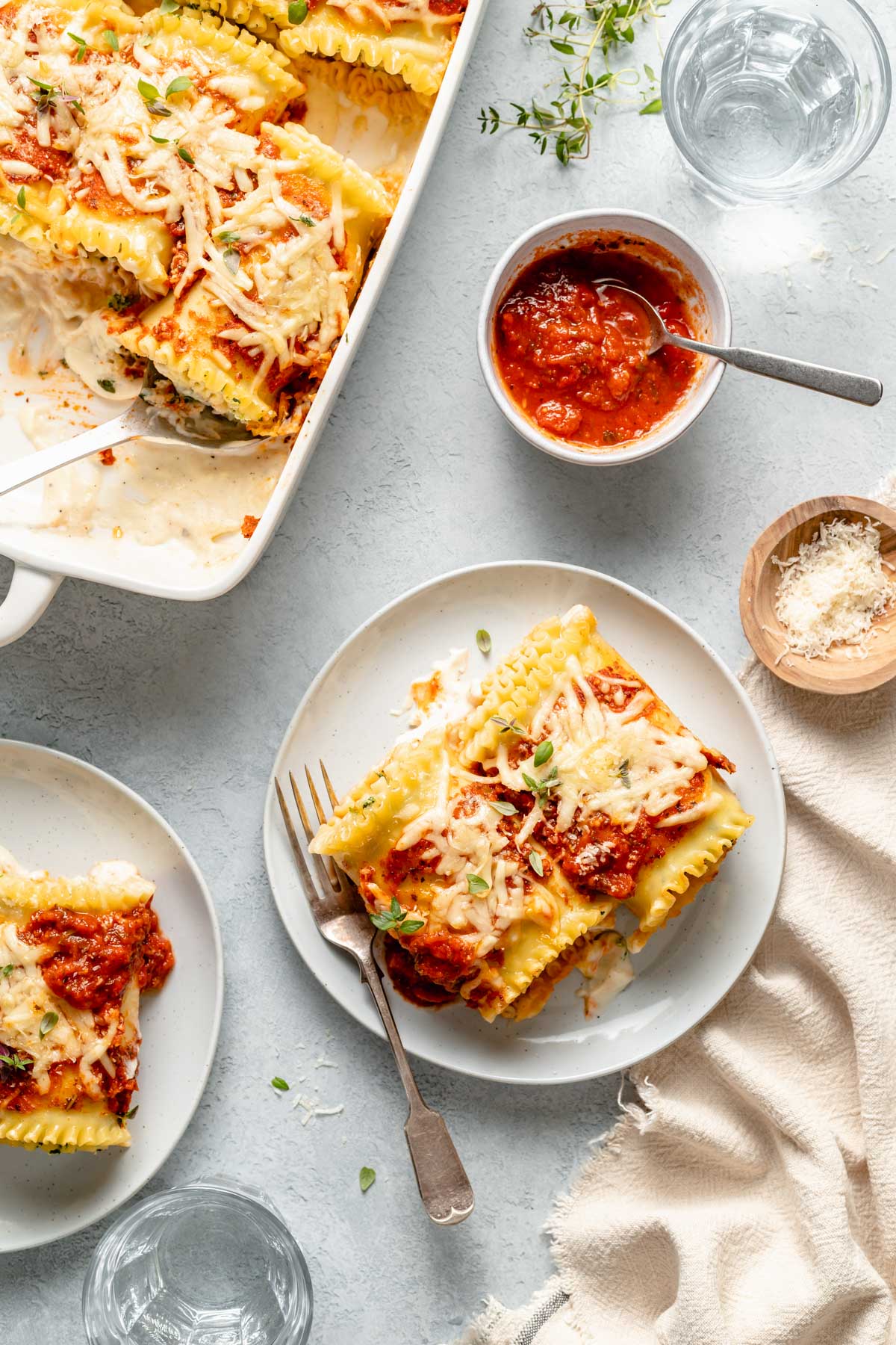 Lasagna roll ups served with a small bowl of marinara sauce.