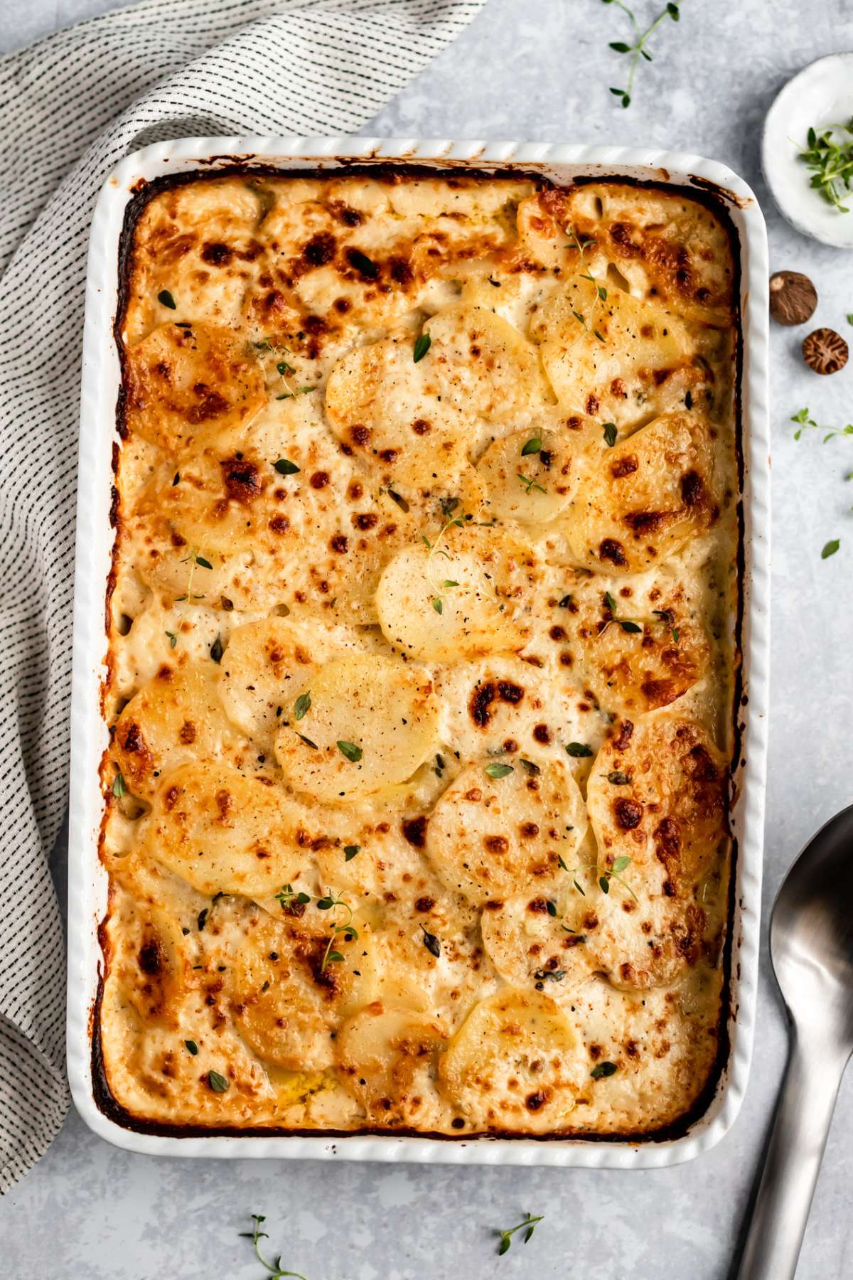 Baked scalloped potatoes in a white casserole dish.