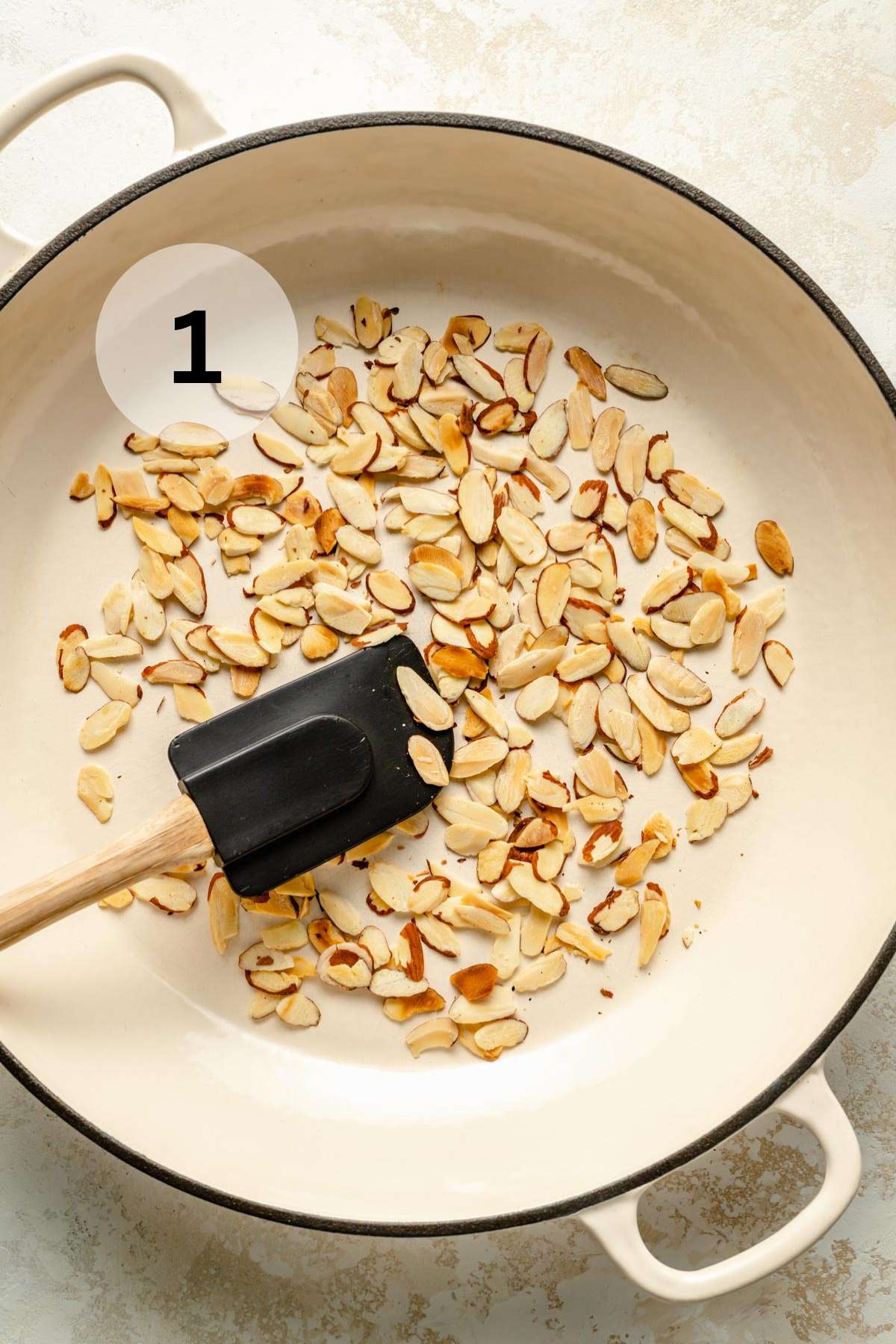 Toasting sliced almonds in a pan.