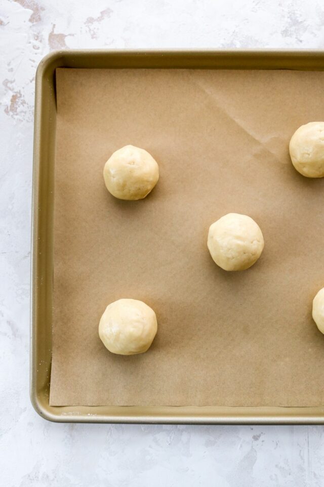 Rolled cookies on a baking sheet pan.