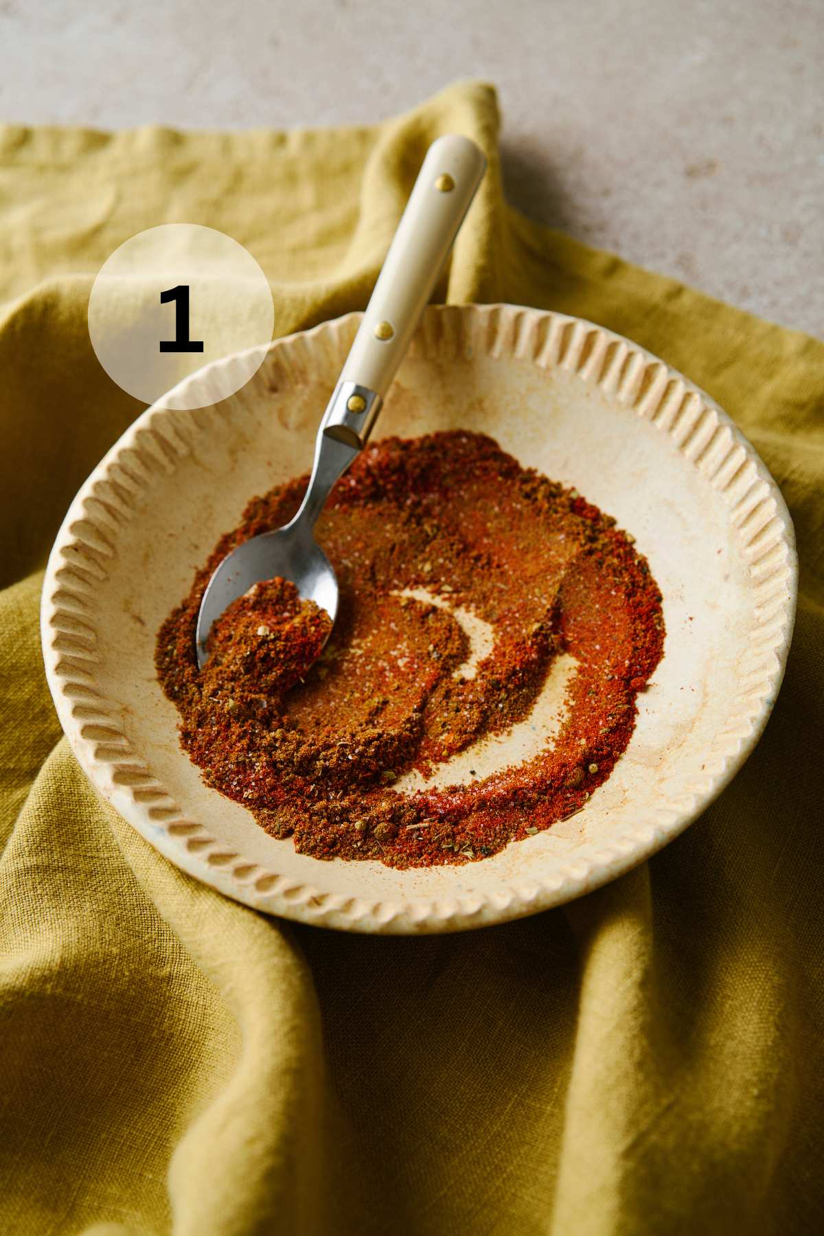 Stirring together spices in a small bowl.