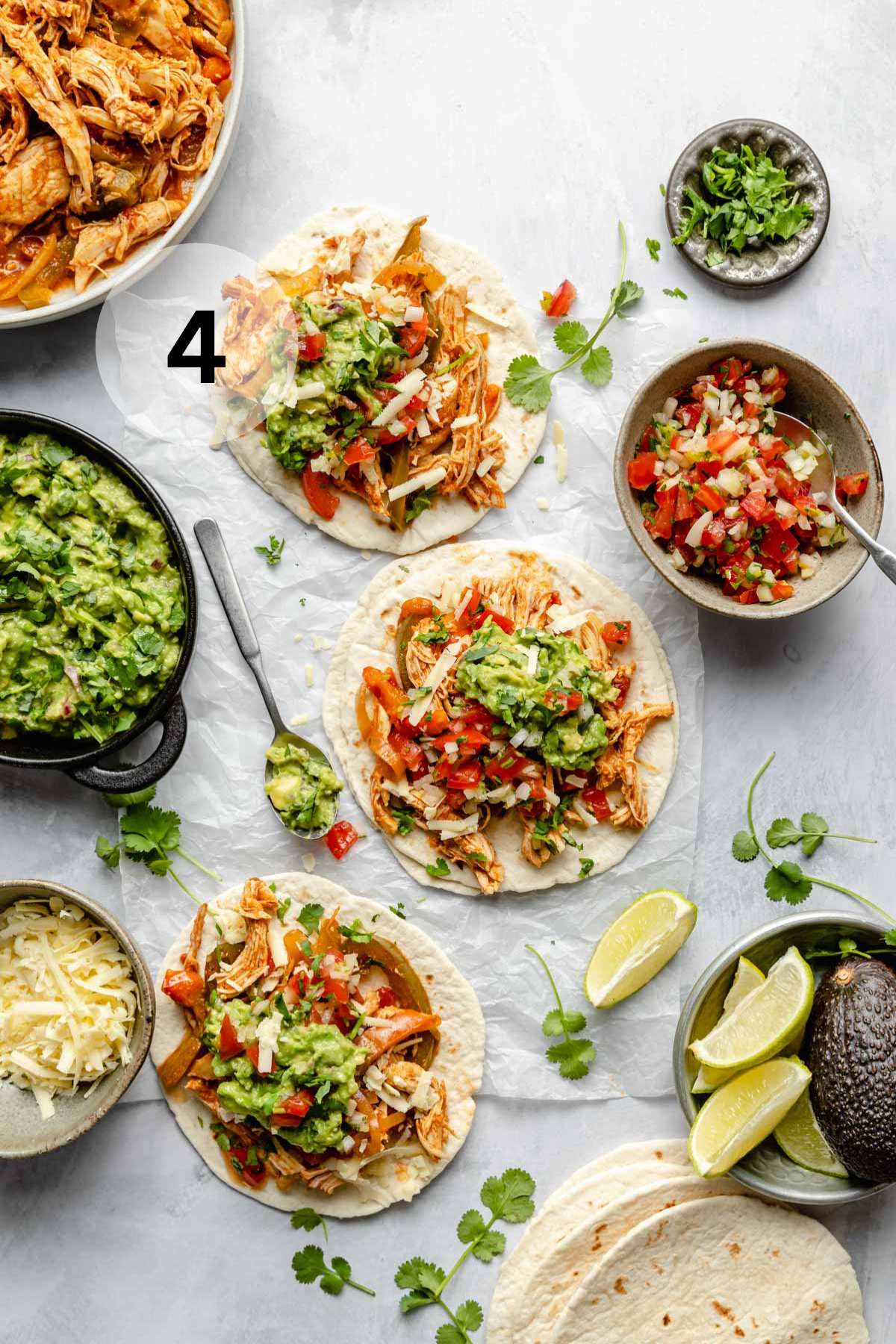 Slow cooker chicken fajitas topped with guacamole and pico de Gallo.