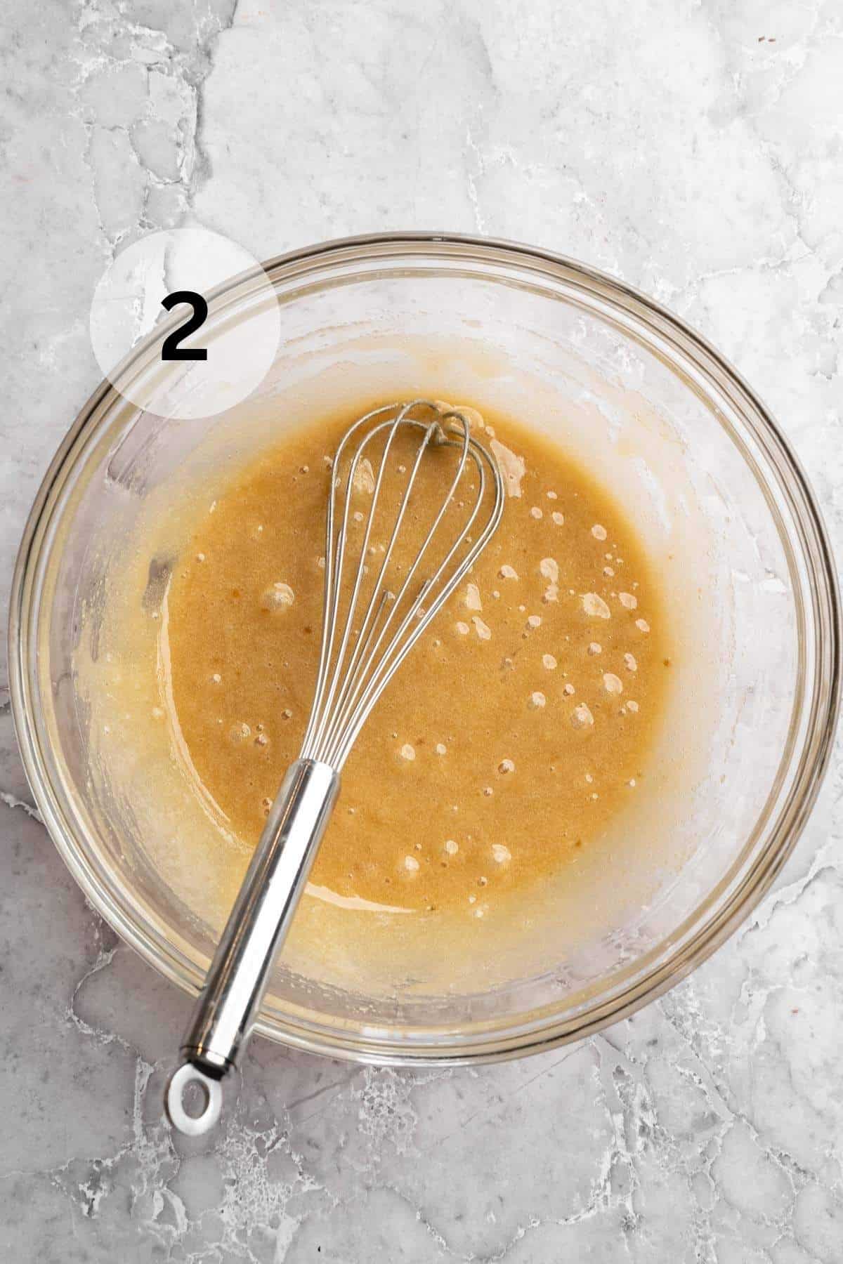 Using a whisk to stir oil, eggs and sugar in a large bowl.