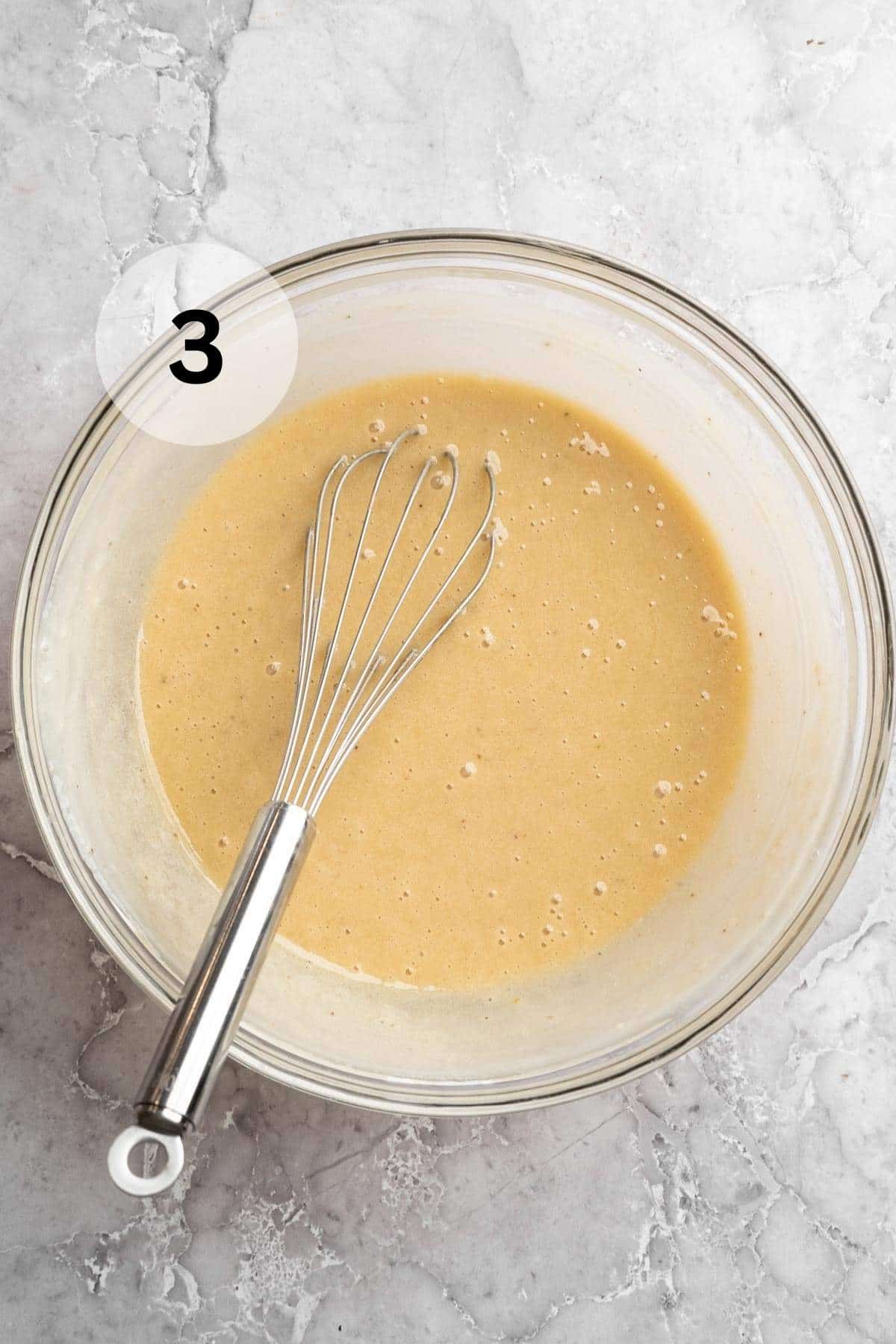 Stirring mashed banana and Greek yogurt with wet ingredients.