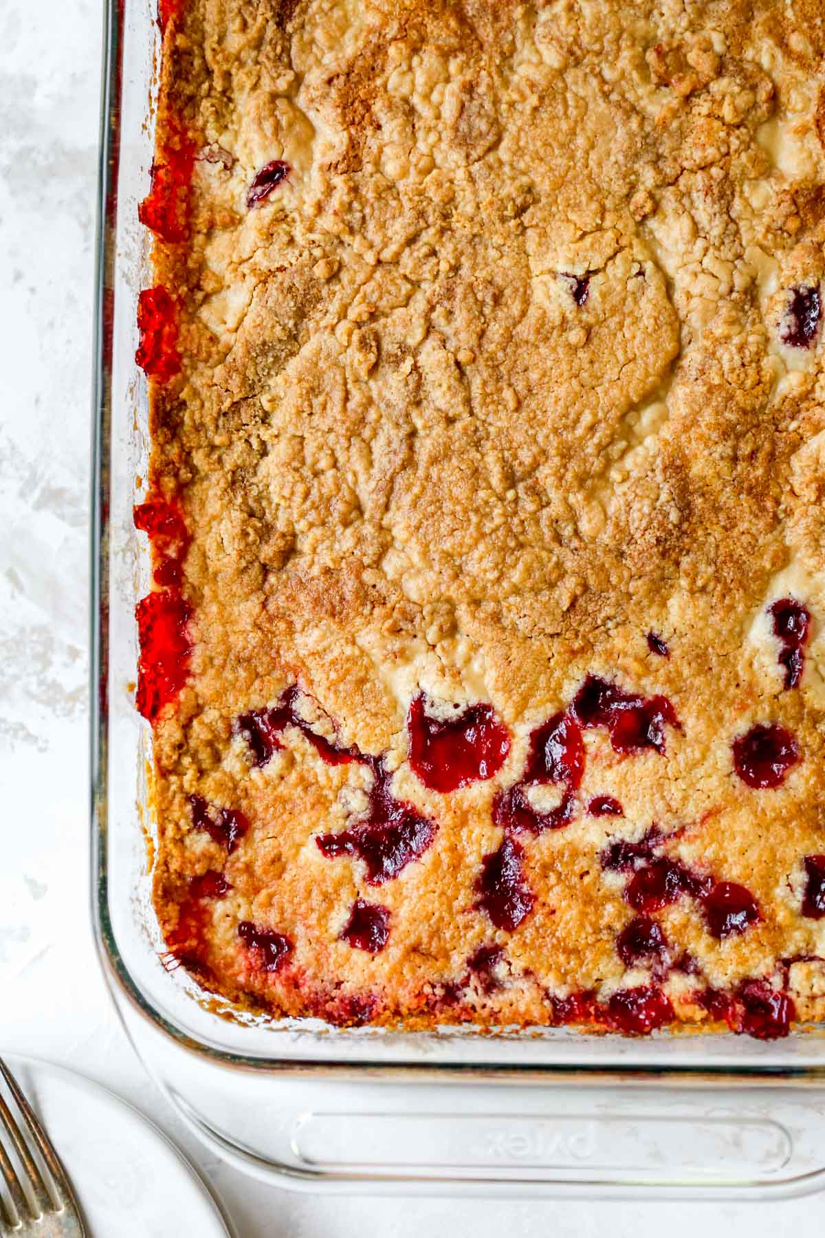 Baked cherry cobbler in a glass baking dish.