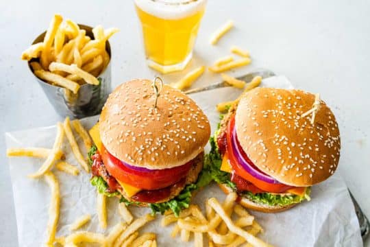 Hamburgers served with toppings and fries.