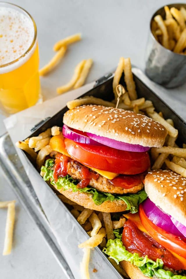 Cheeseburger served with fries and a glass of beer.
