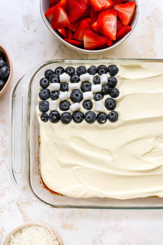Adding blueberries and mini marshmallows in the corner of the cake.