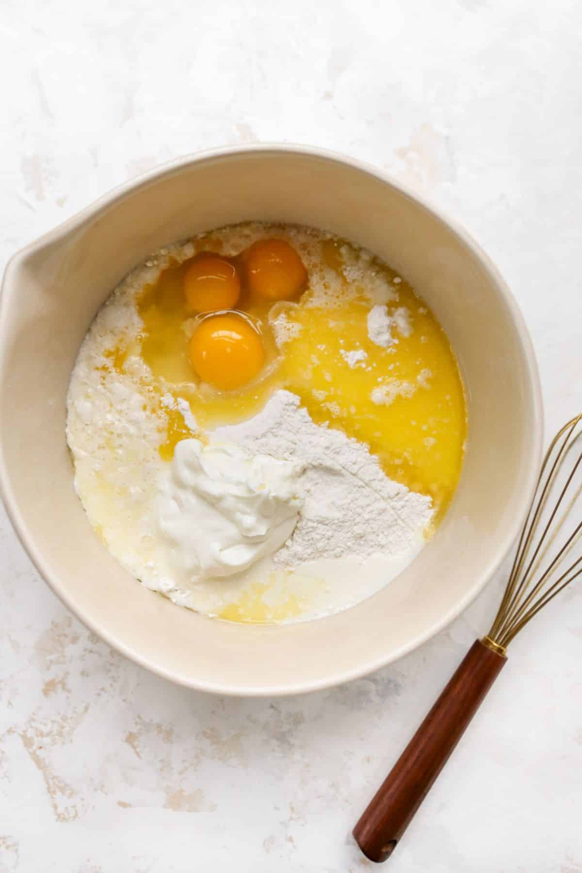 Mixing eggs and sour cream with cake mix in a large bowl.