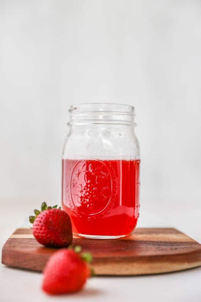 Strawberry simple syrup in a mason jar.