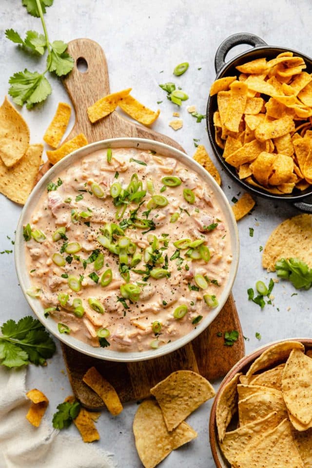 Chip dip served with Fritos and tortilla chips and garnished with green onions.