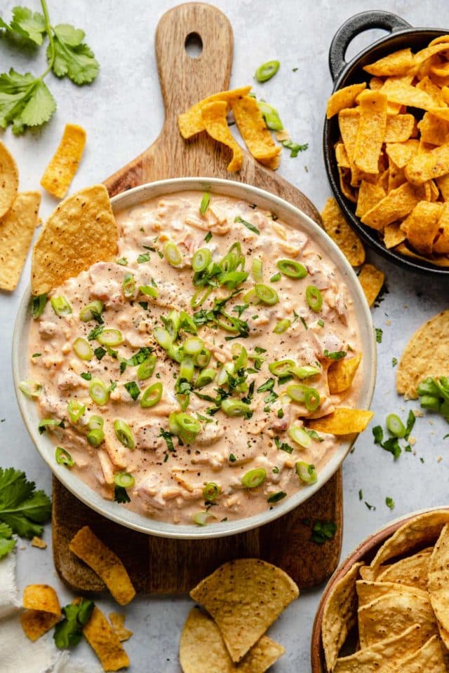 Sour cream dip served with garnish and tortilla chips.