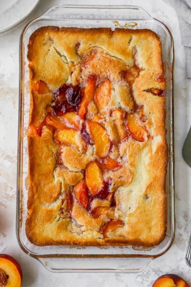 Cooked peach cobbler in a glass baking dish.