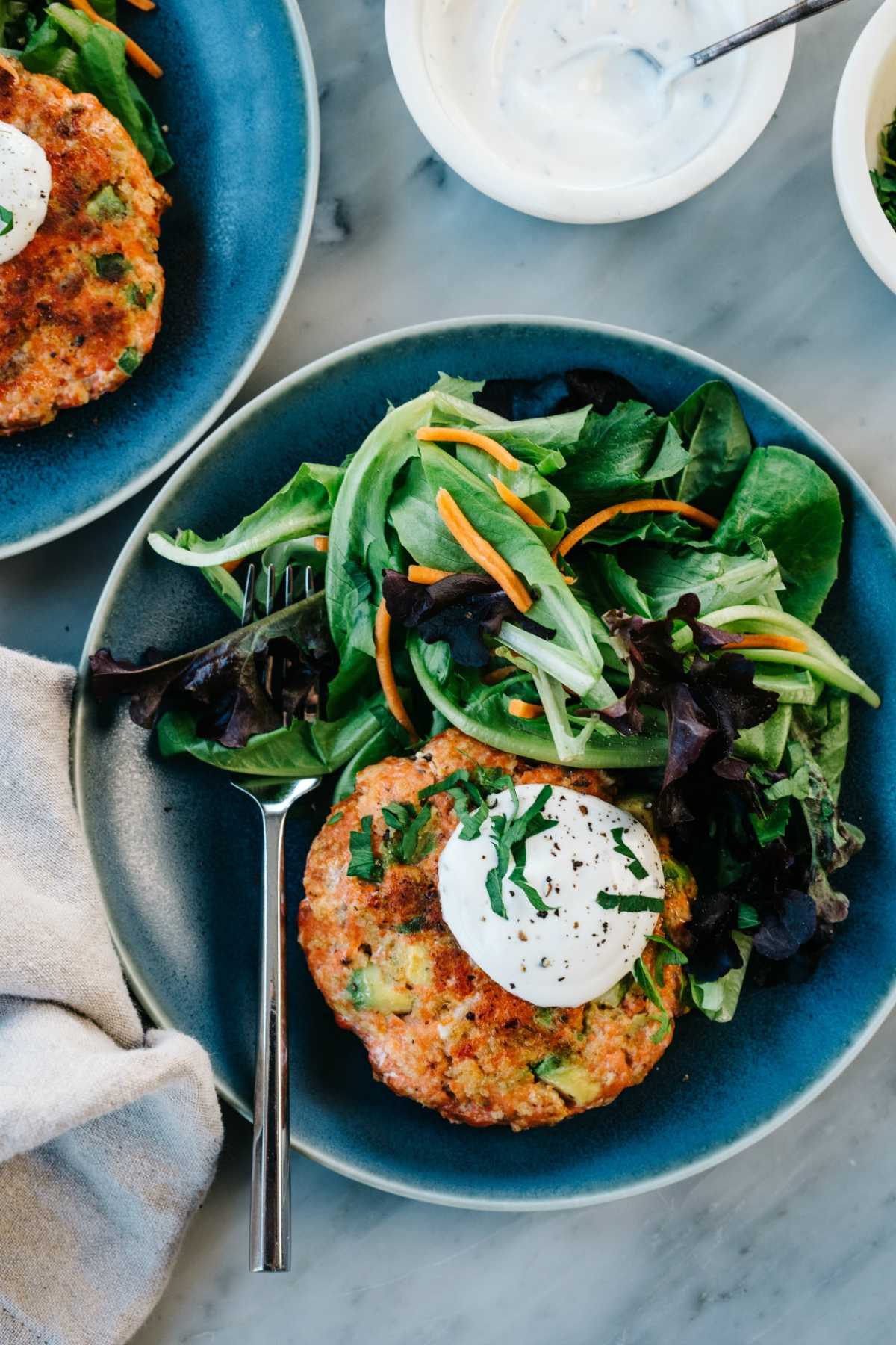 Salmon burger served with greens and homemade ranch dressing.