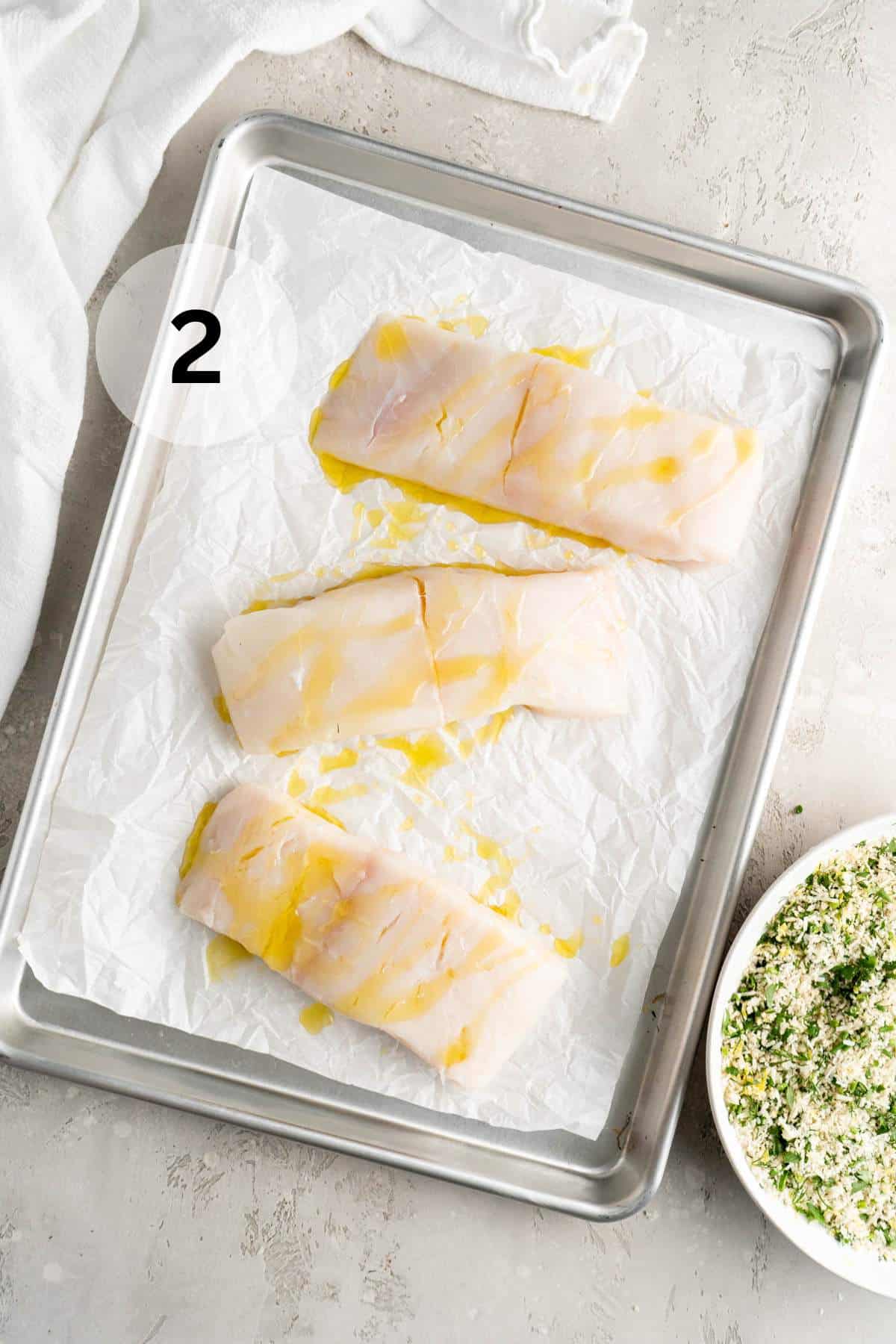 Fish filets on a baking sheet lined with parchment paper.
