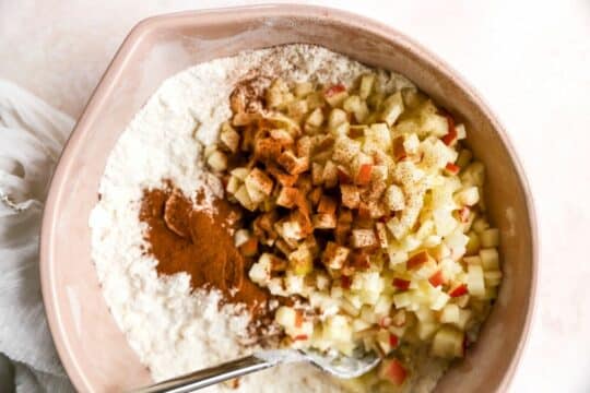 Mixing diced apples with cinnamon and flour.
