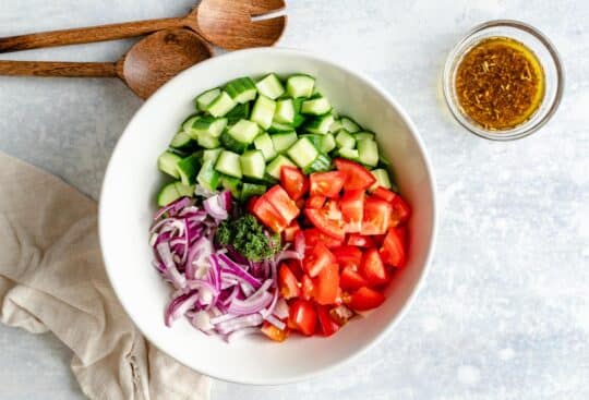 Place chopped cucumber, tomato and red onion in a large bowl.
