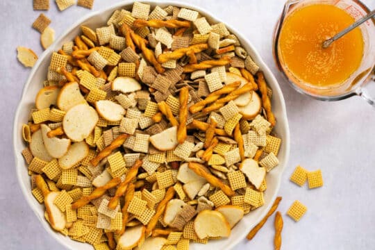 Mixing Chex mix, pretzels and bagel chips in a large bowl.