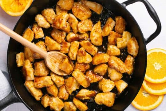 Cooking chicken with sauce in a skillet.
