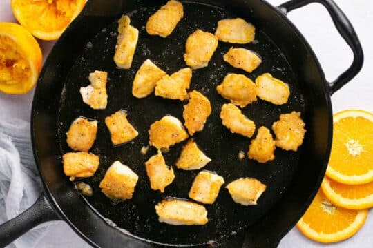Cooking bite-size pieces of chicken in a skillet.
