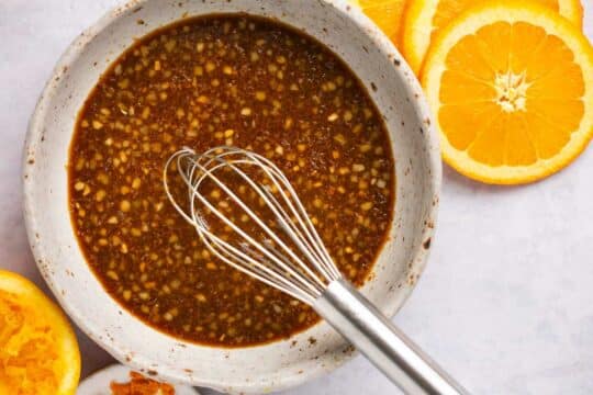 Orange sauce whisked in a small bowl.