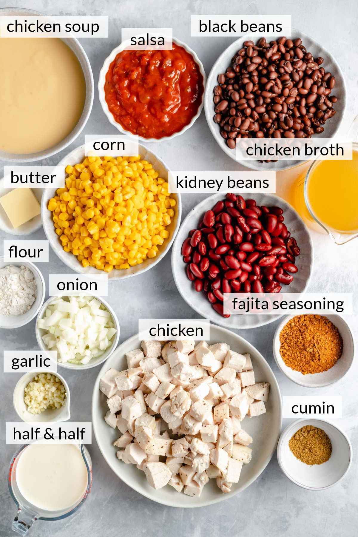 Chicken, beans, corn, seasonings, broth and cream divided into bowls.