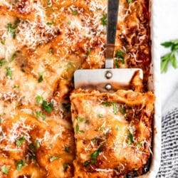 Using a spatula to scoop out a serving of lasagna.