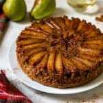 Upside down pear cake on a white serving plate.