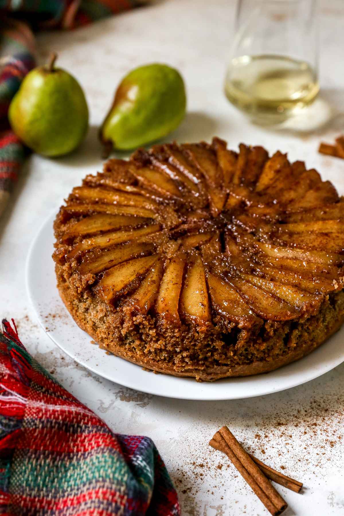Upside down pear cake on a white serving plate.