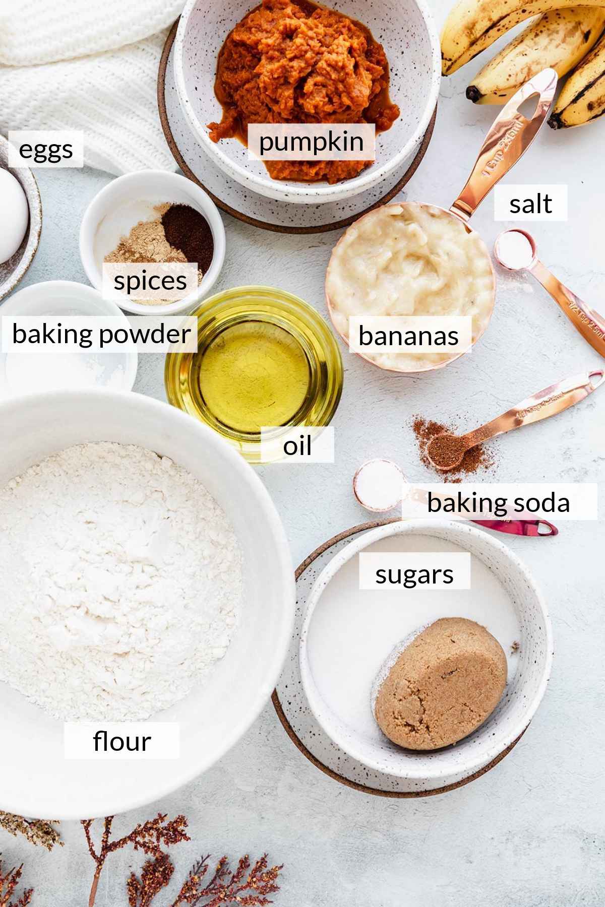 Flour, mashed banana, pumpkin puree, oil and spices divided into bowls.