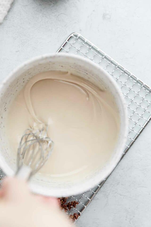 Whisking together glaze in a small bowl.