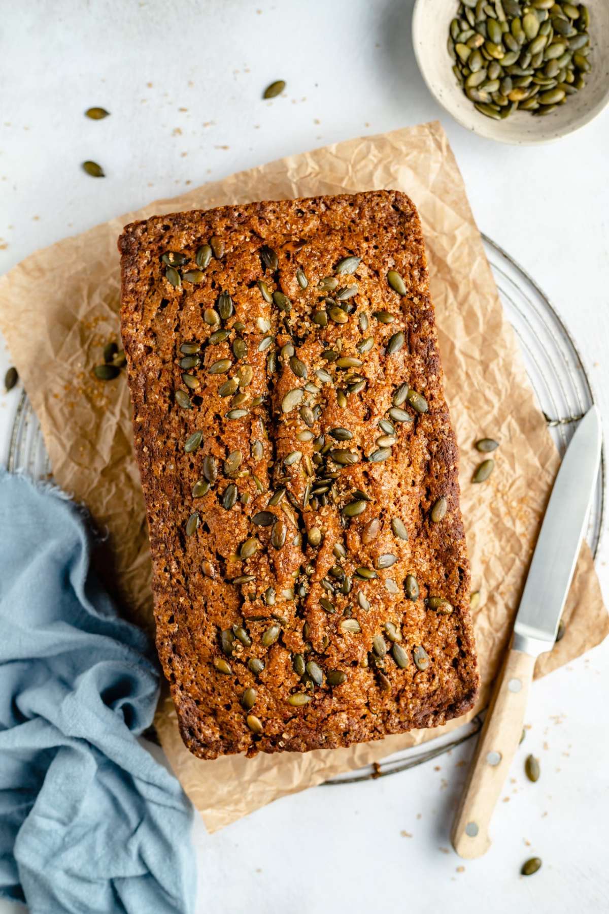 Loaf of pumpkin bread topped with pumpkin seeds.