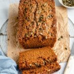 Sliced loaf of bread topped with pumpkin seeds.