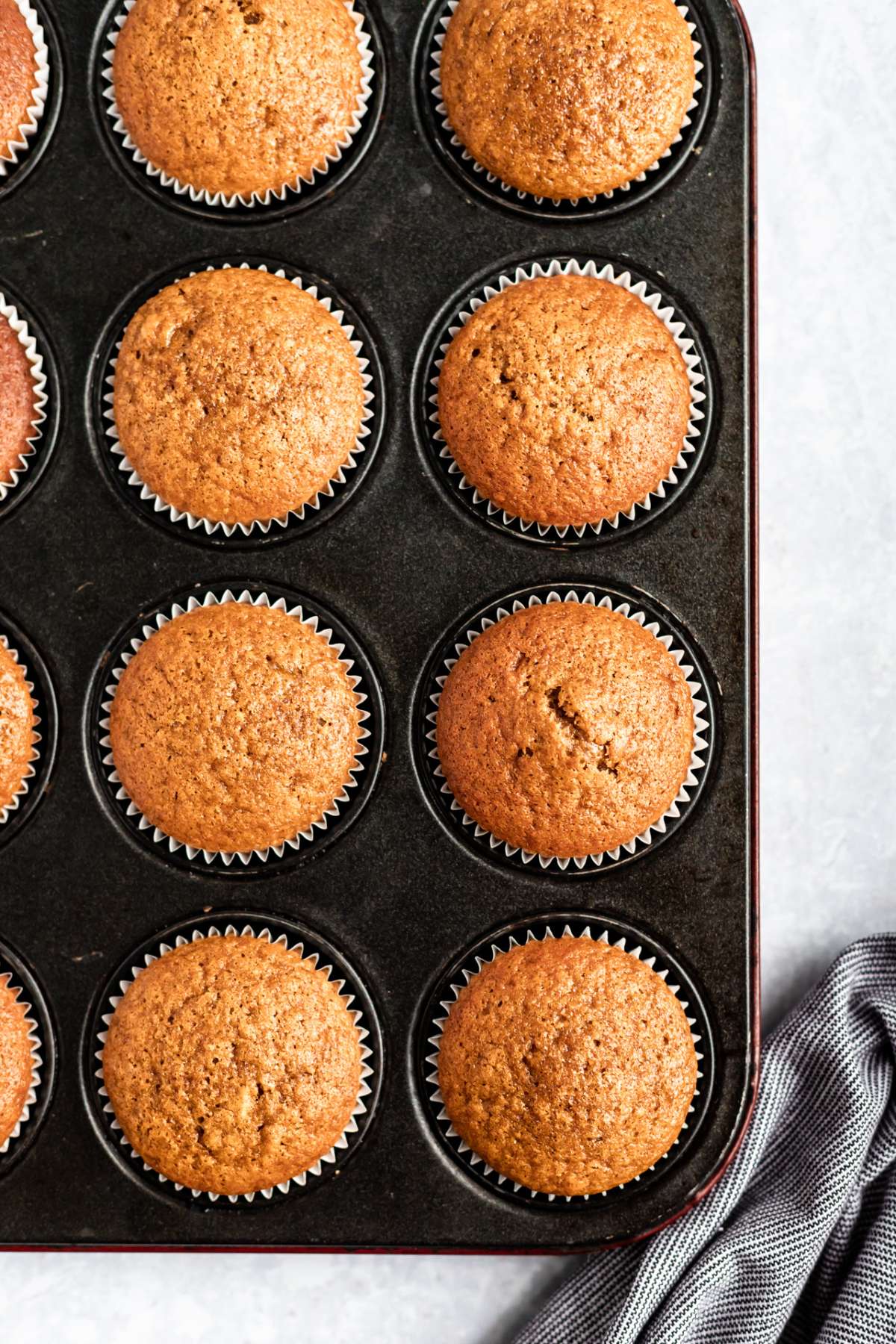 Baked pumpkin cupcakes in a muffin tin.