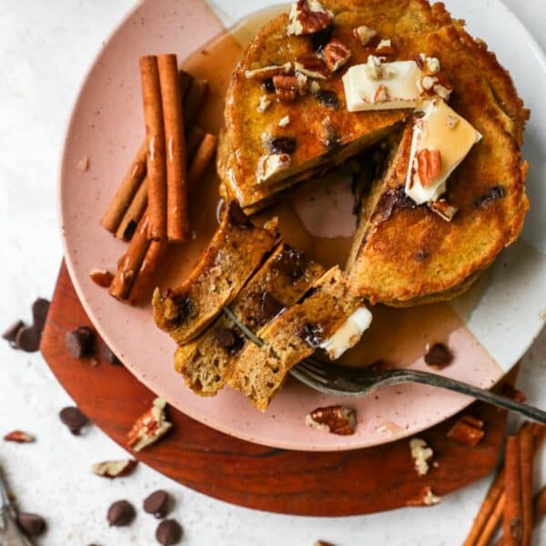 Pumpkin pancakes with chocolate chips and topped with chopped pecans and butter.