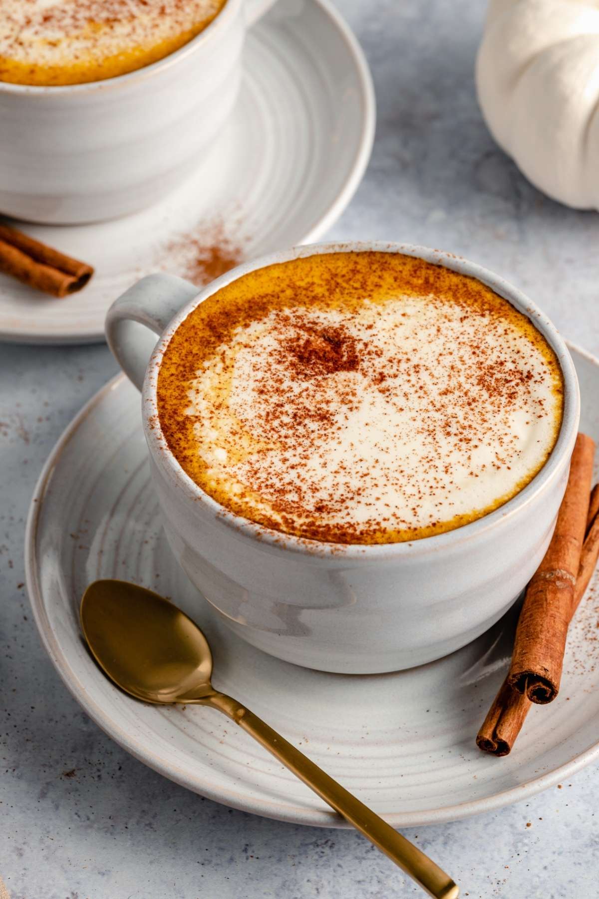 Mug of coffee made topped with foamy cream and spices.