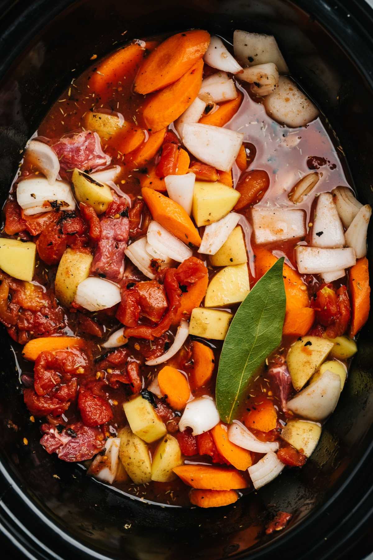 Carrots, onions, beef and potatoes in a crockpot.