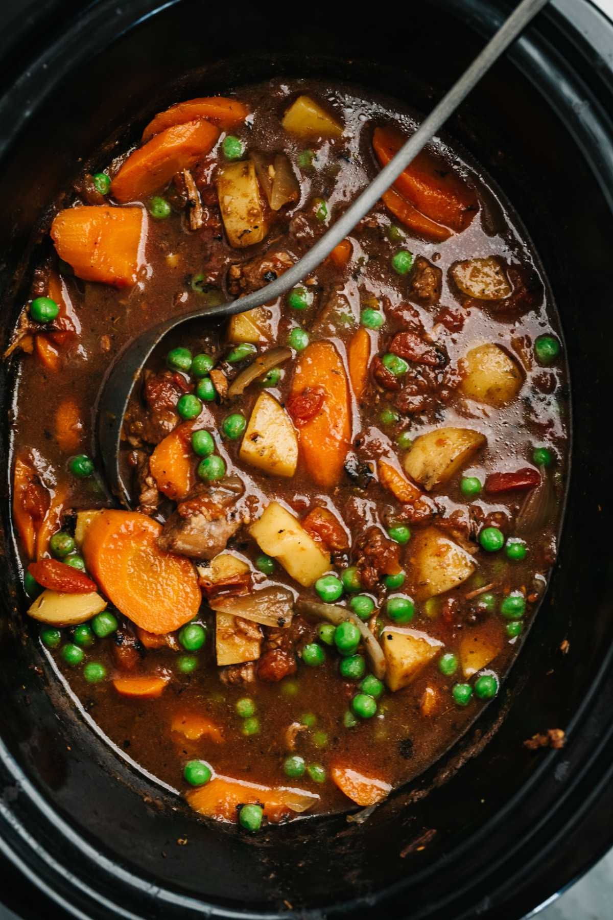 Vegetable beef soup cooking in a slow cooker.