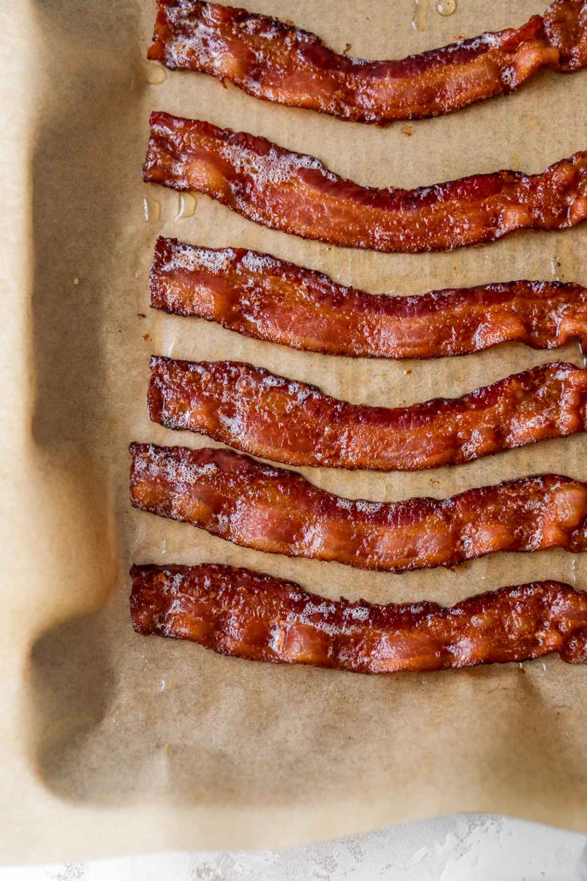 Slices of cooked bacon on parchment.