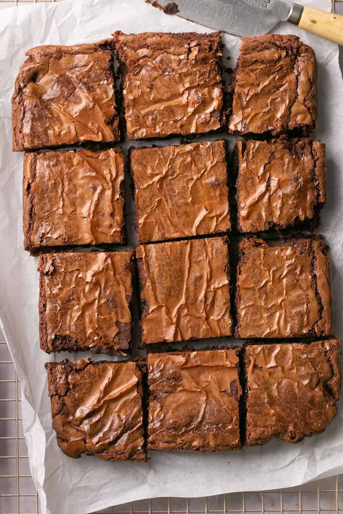 Brownies cut on parchment paper.