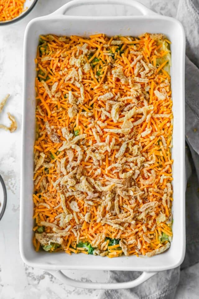 Topping casserole with shredded cheese and fried onions.