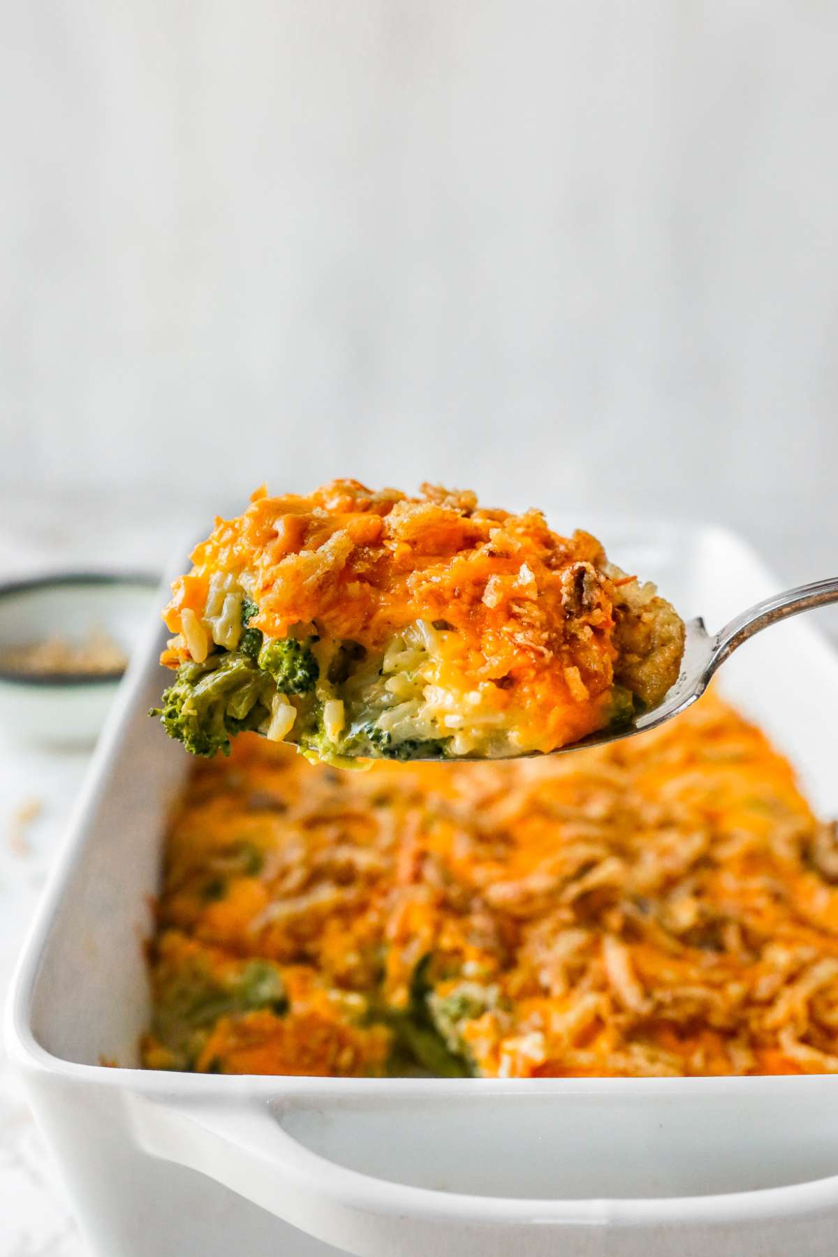 Serving broccoli rice casserole out of a baking dish.