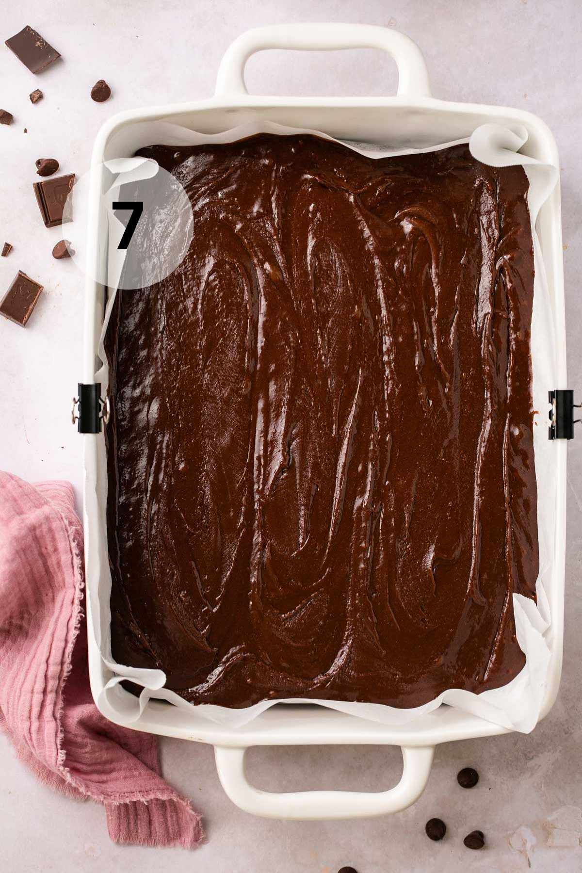 Brownie batter in a parchment lined dish.