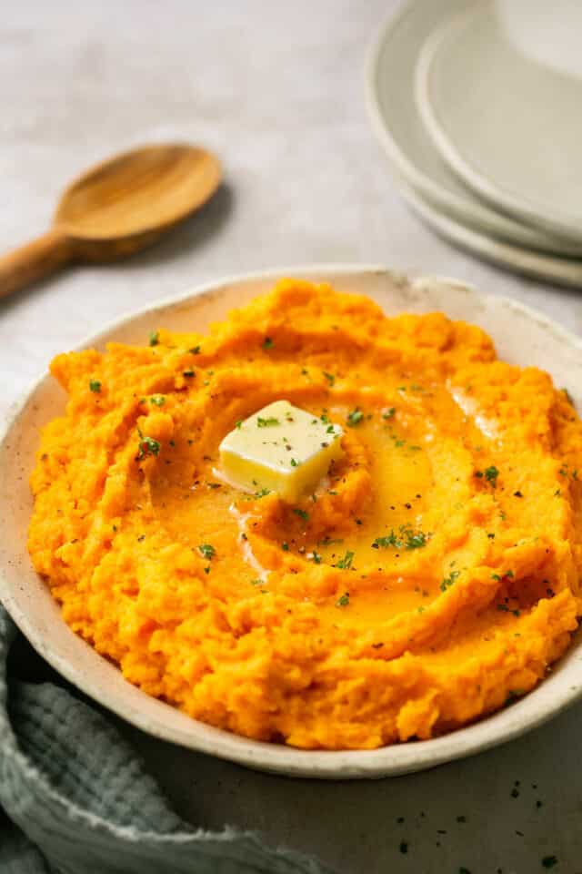 sweet potatoes mashed and served with butter in a bowl.