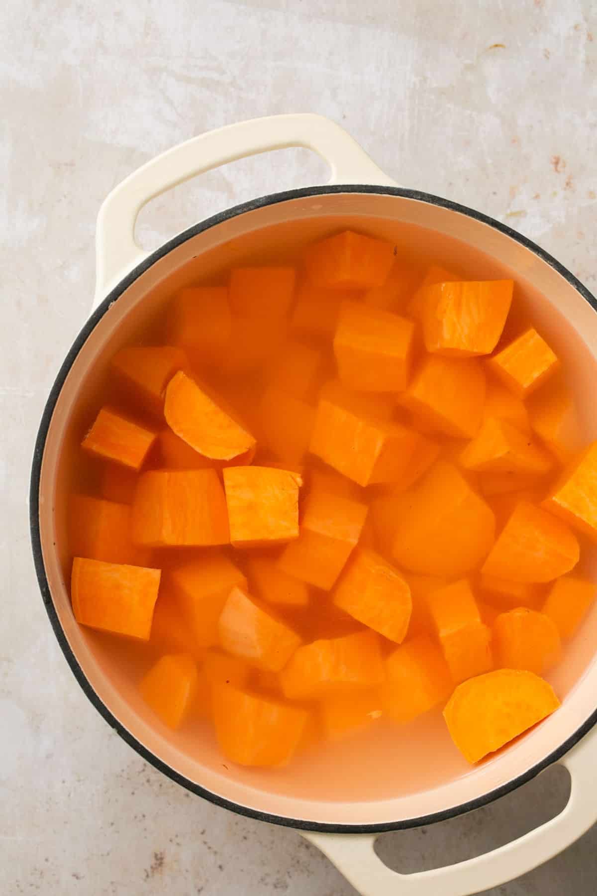 Cubed sweet potatoes in water in a pot.