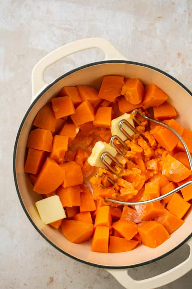 Mashing butter with cubed sweet potato.