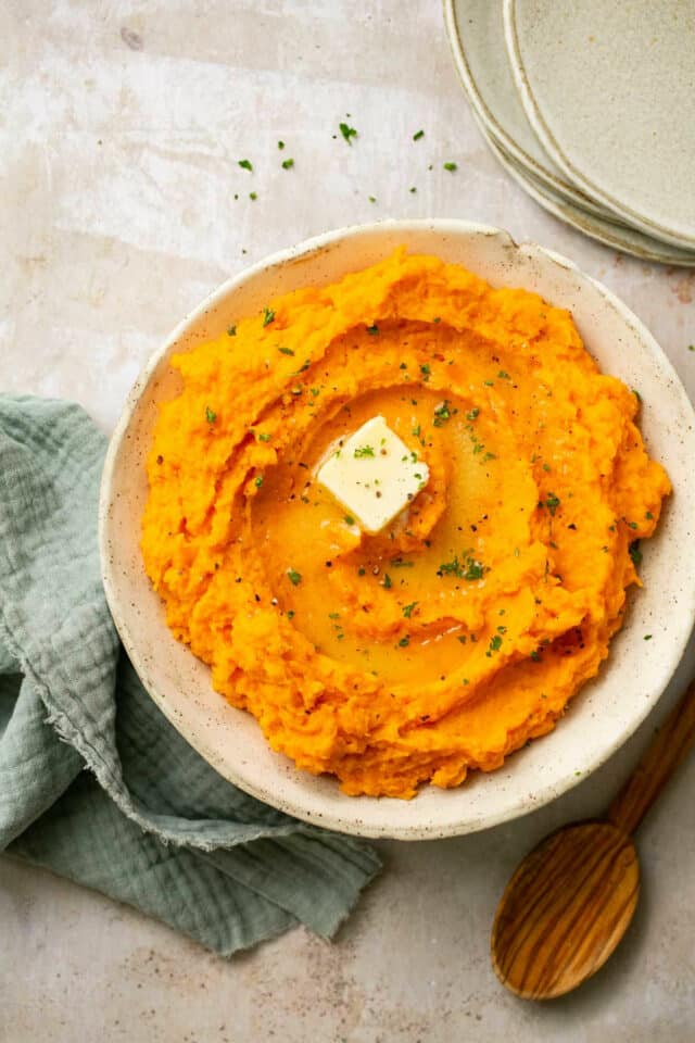 Potato mash topped with butter and garnished with fresh parsley.