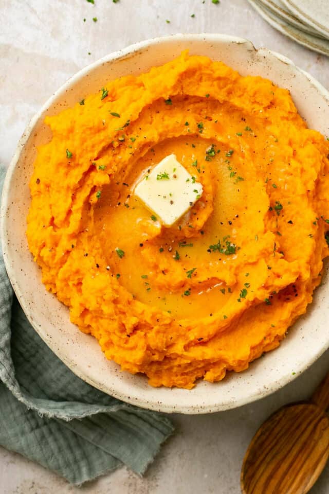 Mashed sweet potatoes topped with a pat of butter.